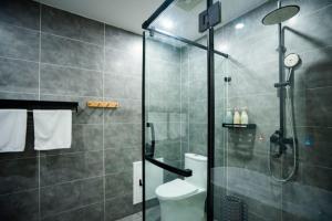 a bathroom with a shower and a toilet at Heinemann Hotel standard king room Building A with a jacuzzi and a local in Baoguosi