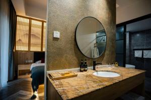 a bathroom with a sink and a mirror at Heinemann Hotel standard king room Building A with a jacuzzi and a local in Baoguosi