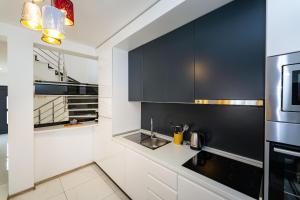 a kitchen with black and white cabinets and a sink at Villa Essenza Mare in Vodice with private pool & pet friendly - only 650 meters from the beach in Vodice +37 photos