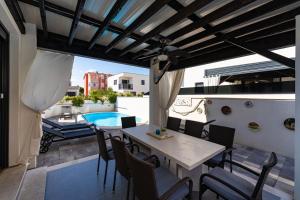 a patio with a table and chairs and a pool at Villa Essenza Mare in Vodice with private pool & pet friendly - only 650 meters from the beach in Vodice
