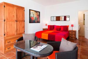 Un dormitorio con una cama y una mesa y sillas. en El Nido, en Almuñécar