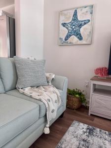 a living room with a blue couch with a blanket at Chic Beach Home Near Airport Casino Coliseum Base in Gulfport