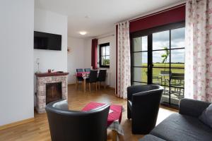 a living room with a fireplace and a table with chairs at Am Wiesengrund in Lebus