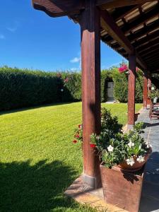 a wooden pergola with two potted plants on a lawn at Villa Baia Verde in Marina di Modica