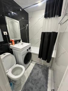 ein Badezimmer mit Toilette, Waschbecken und Dusche in der Unterkunft Квартира 1,5 Евро-люкс in Öskemen