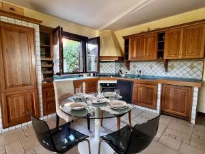 a kitchen with a table with wine glasses on it at Villa Baia Verde in Marina di Modica +6 photos