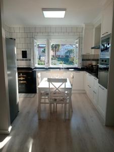 a white kitchen with a table and a window at La casa de la avioneta in Argoños