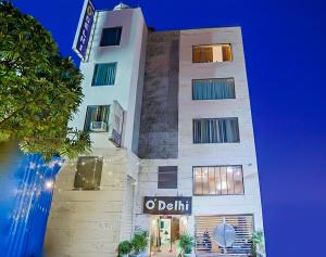 a tall white building with a sign on it at Hotel O" Delhi-Near Karol Bagh Metro Station in New Delhi