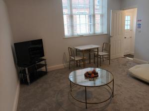 a living room with a table and a tv at Fabulous 1 bed flat Central Ipswich Parking in Ipswich
