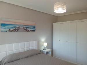 a bedroom with a bed and a picture of a pier at La casa de la avioneta in Argoños