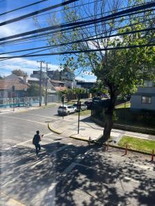 a man walking down a street with a fire hydrant at Hostal Constitución in Chillán