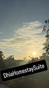 Un cartel en el lateral de un coche con la puesta de sol de fondo. en Suites Kampung Homestay, en Kuala Ketil