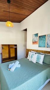 a bedroom with a large green bed with two pillows at Pousada Oceano Atlântico in Marau