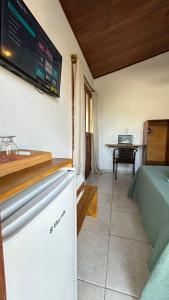 a room with a tv on the wall and a table at Pousada Oceano Atlântico in Marau
