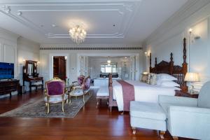 a bedroom with a large bed and a living room at Ping Pura Riverside Resort & Spa Chiang Mai in Chiang Mai