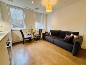 ein Wohnzimmer mit Sofa und Tisch in der Unterkunft Charming 1BR City Retreat soho&covent garden in London