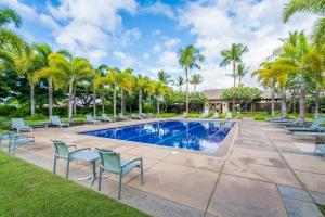 una piscina con sillas y palmeras en Relax Unwind in Paradise Kulalani 203, en Waikoloa