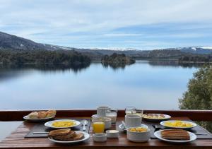 a table with breakfast foods and a view of a lake at Aparts La Balconada by DOT Suites in Villa Pehuenia