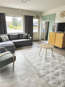 een woonkamer met een bank en een tafel bij Viihtyisä esteetön saunallinen asunto entisellä paloasemalla in Sievi +11 foto's