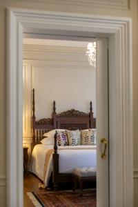 a bedroom with a bed with white sheets and pillows at Ping Pura Riverside Resort & Spa Chiang Mai in Chiang Mai