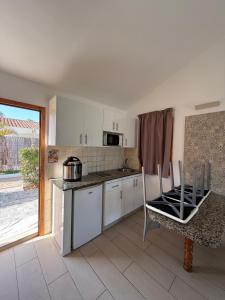 a kitchen with white cabinets and a table and chairs at Secret Bungalow, Los Arcos in San Bartolomé