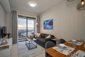 a living room with a couch and a table at The Luxe Collection Sun Avenue Riverside District 2 Suite in Ho Chi Minh City