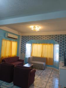 スービックにあるViolas Placeのリビングルーム(ソファ2台、黄色のカーテン付)