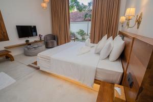 a bedroom with a bed with white sheets and pillows at Madiha Venus in Matara