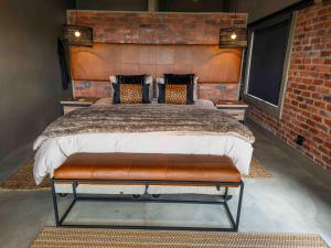 a bedroom with a large bed in a brick wall at vanDijksRus Farm in The Waterberg Biosphere