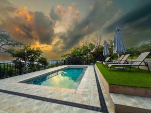a swimming pool with two chairs and an umbrella at vanDijksRus Farm in The Waterberg Biosphere