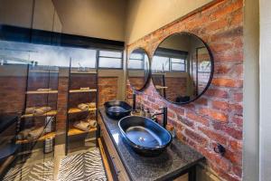a bathroom with two sinks and a brick wall at vanDijksRus Farm in The Waterberg Biosphere +22 photos
