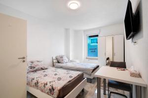 una habitación con dos camas y un escritorio y una mesa en Haus Rosa, en Albstadt