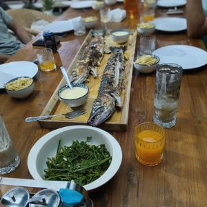 a wooden table with a bunch of fish and vegetables at Turtle Garden Lodge in Semporna