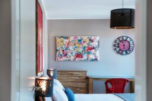 a bedroom with a bed and a clock on the wall at Terrazza Paradiso by Quokka 360 - Spacious Design Flat with Terrace in Paradiso +49 photos