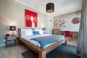 a bedroom with a large bed and a red painting at Terrazza Paradiso by Quokka 360 - Spacious Design Flat with Terrace in Paradiso