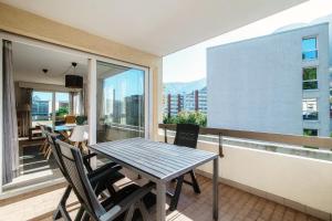 a balcony with a table and chairs and a large window at Terrazza Paradiso by Quokka 360 - Spacious Design Flat with Terrace in Paradiso