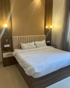 Un dormitorio con una cama grande con sábanas blancas. en Blessing Inn Hotel, en Jalandhar
