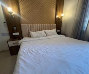 una cama blanca grande en una habitación de hotel en Blessing Inn Hotel, en Jalandhar