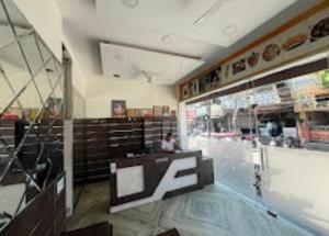 una persona sentada en un mostrador de una tienda en Blessing Inn Hotel, en Jalandhar