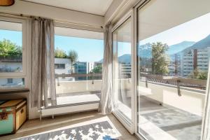 an apartment balcony with large windows and mountains at Terrazza Paradiso by Quokka 360 - Spacious Design Flat with Terrace in Paradiso