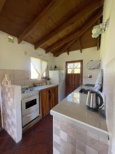 a kitchen with a stove and a refrigerator at Cabaña Cordón Situación in Trevelín
