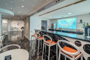 a bar with white and orange chairs in a restaurant at La Boutique Puerta Osario in Córdoba
