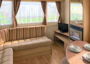 a living room with a couch and a table at The Chase Holiday Park in Winthorpe