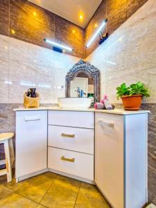 a bathroom with a white sink and a mirror at Blue vibes in Flic-en-Flac
