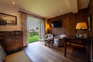 a living room with a desk and a chair and a window at The Bay Tree Hotel in Burford
