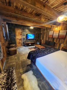 a bedroom with a large bed and a flat screen tv at The Adventurers Resort in Dhechiān di Bahlk