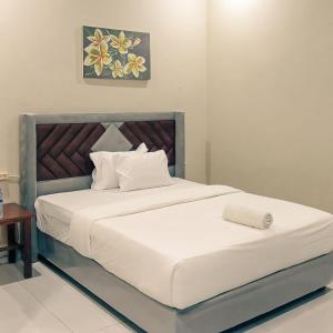 a bedroom with a large bed with white sheets at Ayu Homestay in Kuta Lombok