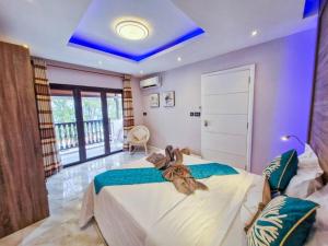 a bedroom with a large bed with a blue ceiling at Blue vibes in Flic-en-Flac