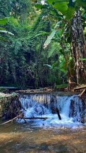 a small waterfall in the middle of a river at Hula Hula Sunset, Dome in Pai