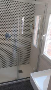una ducha con una puerta de cristal junto a un lavabo en La Casa al Mare, en Lerici